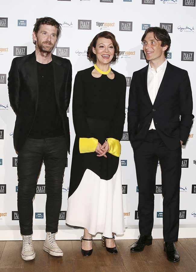 Paul Anderson, Helen McCrory and Cillian Murphy pose for pictures against a background of logos