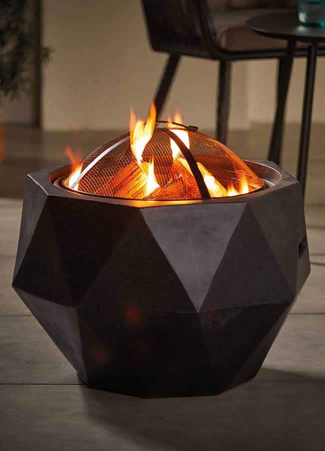 An Aldi lit fire pit is seen on a decking