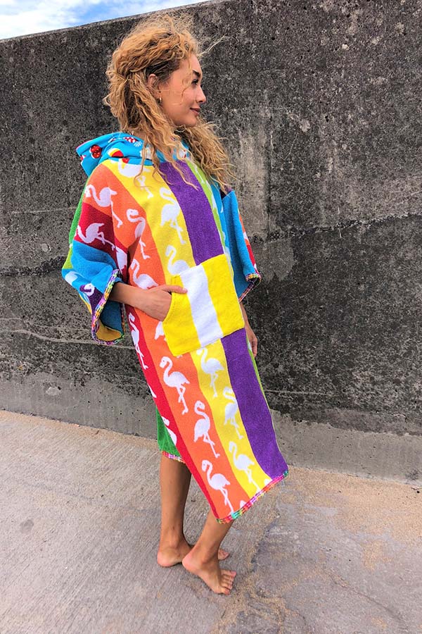 A model stands against a wall outside wearing a colourful dryrobe
