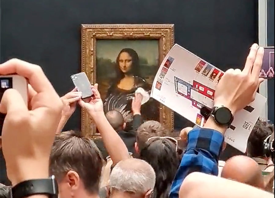 Priceless masterpiece The Mona Lisa 'pied' by a climate change protester disguised as a woman in a wheelchair