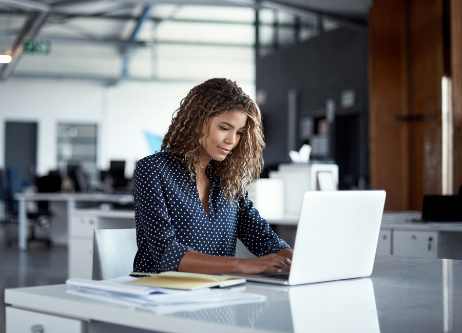 woman writing OOO at office desk