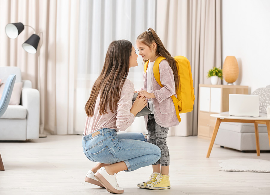 Young mother helping her daughter get ready for school